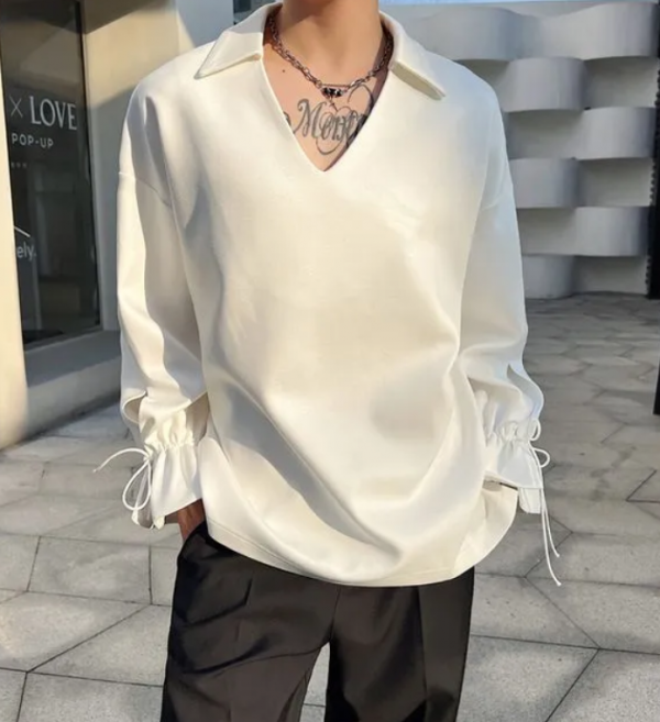 Kemeja dengan lengan panjang dan aksen tali di pergelangan tangan